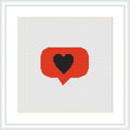 The image presents a cross stitch pattern framed in a white border. The pattern depicts a red speech bubble with a gray border containing a black heart in the center. The stitching is done on a white fabric which makes the colors stand out.