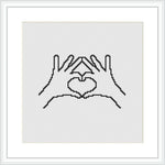 The image shows a framed cross stitch pattern depicting two hands forming a heart shape in the center. The stitches are made in a single color on a plain white canvas.