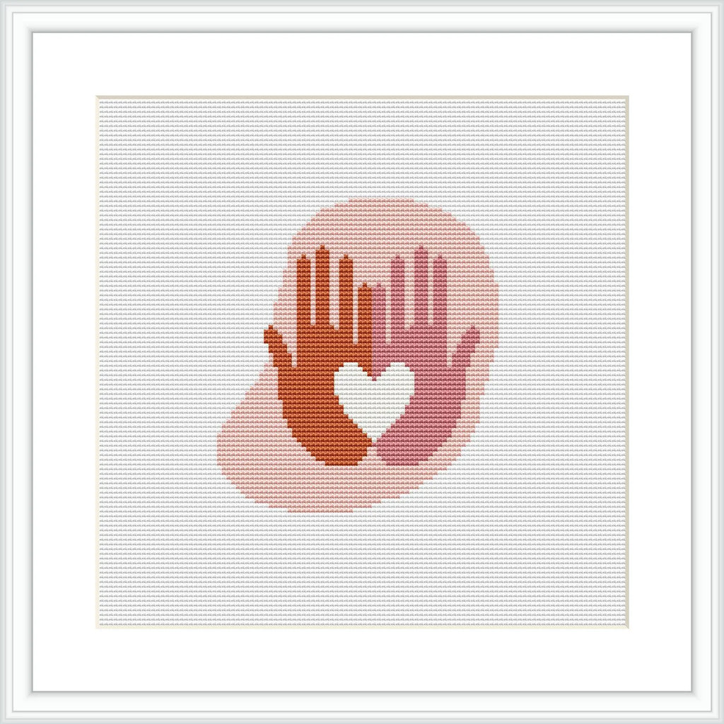 The image displays a framed cross stitch pattern depicting a silhouette of two hands forming a heart shape. The stitches create a gradient effect from reds at the bottom to lighter shades at the top, set against a white background.