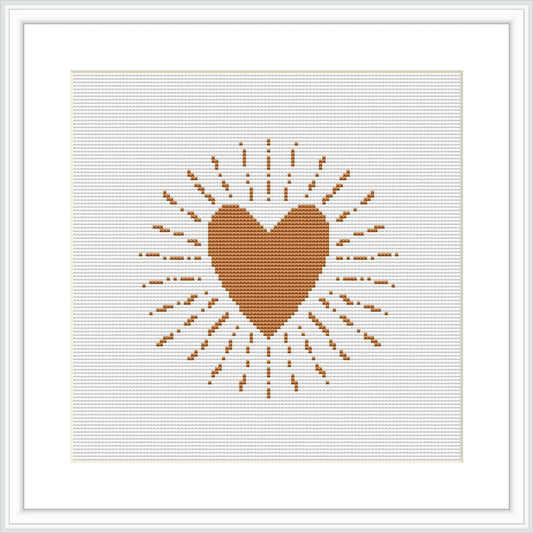 A cross stitch pattern displaying a centered brown heart with radiating lines and dots creating a sunburst effect, displayed on an ivory or white background within a frame.