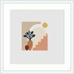 The image features a framed cross stitch pattern with an abstract design represented by geometric shapes including a partial circle, triangle, and organic shapes resembling vegetation, against a multicolored background.