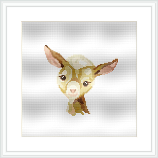 The image features a cross stitch pattern of a baby goat's head and upper shoulders. The goat has large, expressive eyes, and its head is slightly tilted. The background is plain, which highlights the subject matter.