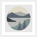 A round cross stitch pattern depicting a minimalist landscape of mountains and foreground trees, placed against a segmented circle background representing the sky.