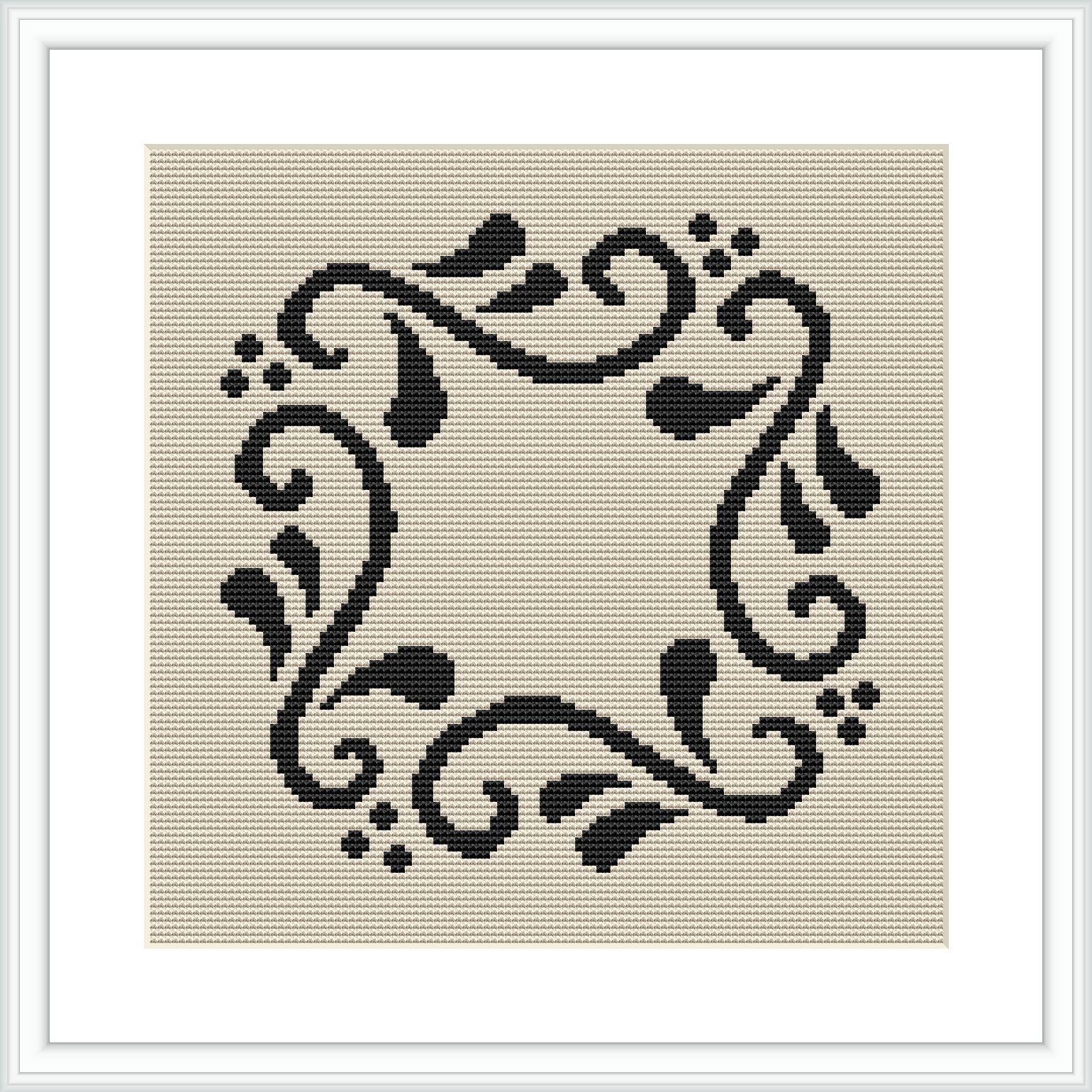 The image shows a square cross stitch pattern with a black floral frame design on a beige canvas, which is framed with a white border. The design is centered and symmetrical, featuring swirling floral elements and dots around an empty central space.