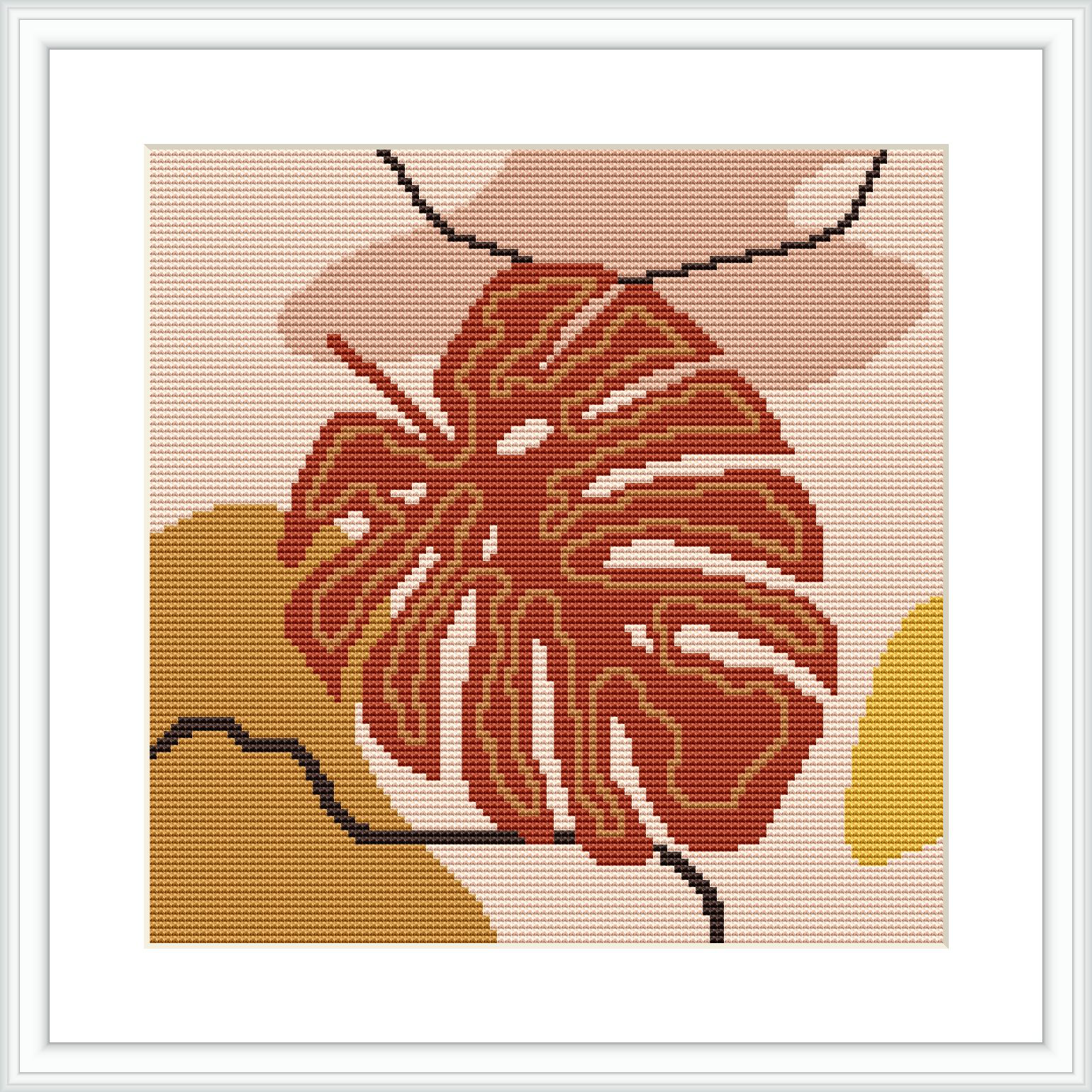 A framed cross stitch pattern of a monstera leaf in earthy tones, with terracotta, beige, and cream colors. The pattern appears to be set against a light-colored background and framed in a simple white frame.