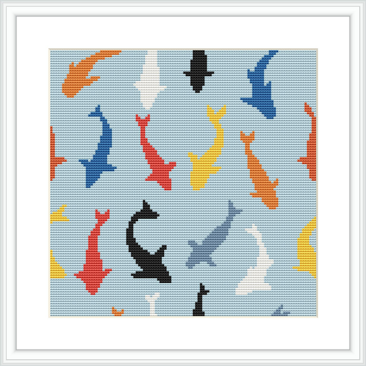 The image shows a cross stitch embroidery pattern of various colored sharks - red, blue, yellow, black, and white, distributed over a light blue background that implies an underwater environment.