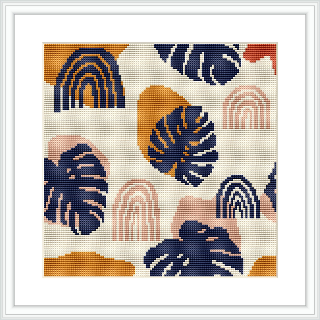 The image shows a framed cross stitch pattern consisting of a symmetric design with tropical monstera leaves and rainbow shapes. The leaves and rainbows are arranged in a modular, repeating pattern with a white background. The colors predominately feature shades of peach, navy blue, mustard yellow, and terracotta.