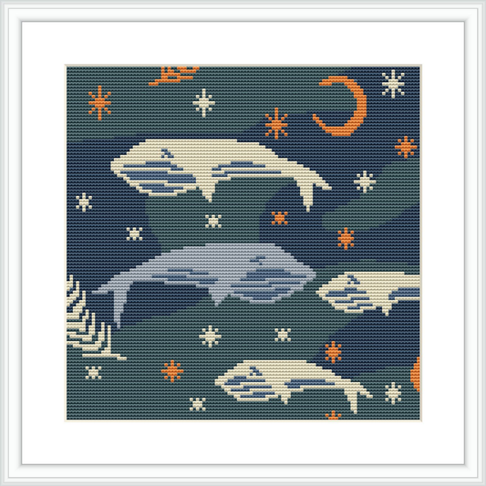 The cross stitch pattern displays an underwater scene with multiple whales in different sizes and positions, surrounded by starfish. Above, there is a crescent moon. The background is predominantly navy blue, simulating the ocean depth.