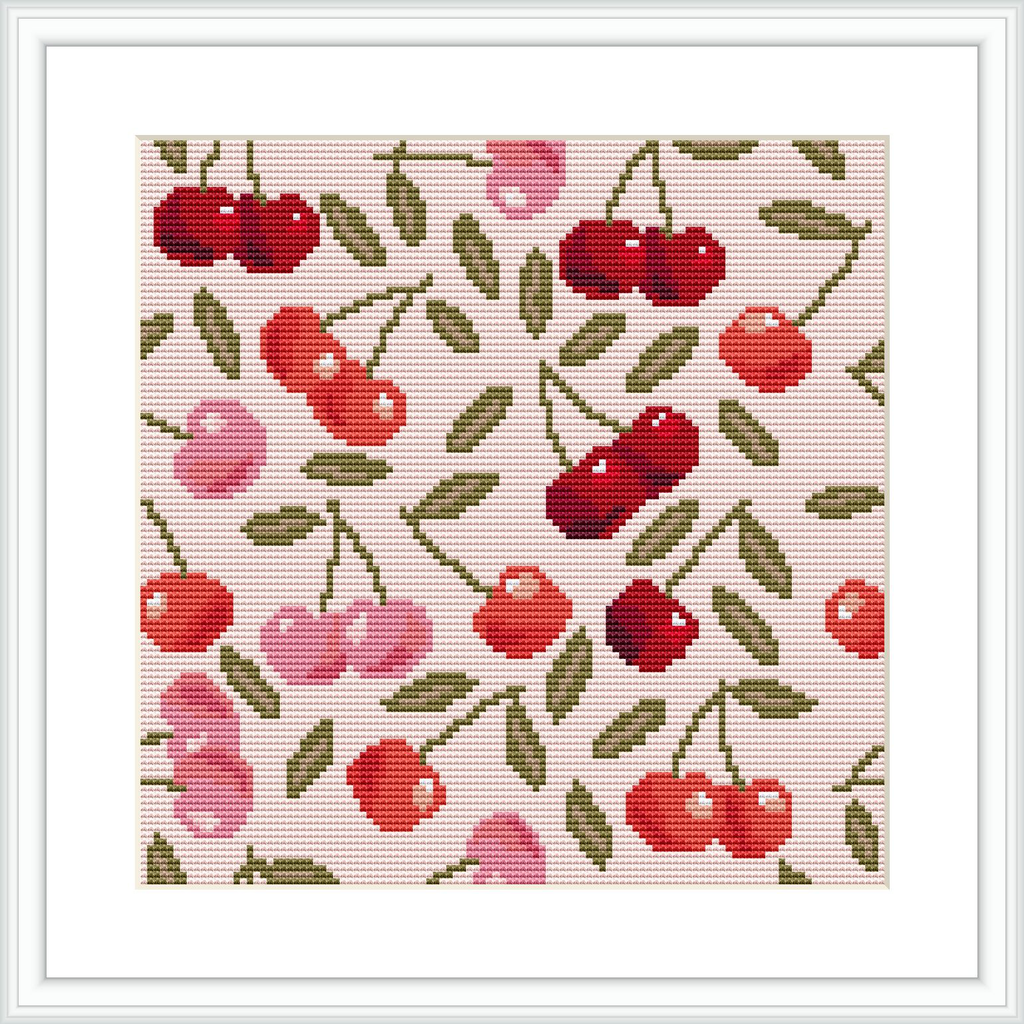 The image depicts a cross stitch pattern featuring a repeat design of red and pink cherries with green leaves scattered throughout, creating a vibrant, summery look against a light beige background.