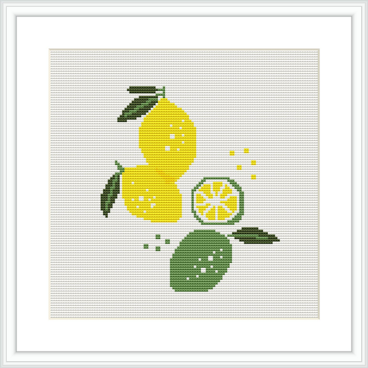 The cross stitch pattern shows a composition of lemons with one of them cut into slices, accompanied by green leaves against a white background. The pattern is framed with a simple flat frame.