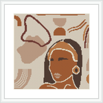 The image showcases a cross-stitch pattern framed in white, depicting a stylized woman with a headscarf and earring. The background includes abstract shapes resembling desert elements.