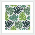 The image shows a cross stitch pattern depicting stylized monstera leaves in various shades of green, arrayed in a repetitive, tessellated design on a white background, framed in white.