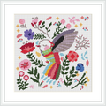 The scene depicts a colorful hummingbird in the center, surrounded by various types of flowers and leaves in multiple hues, stitched against a white background, all within a square frame.