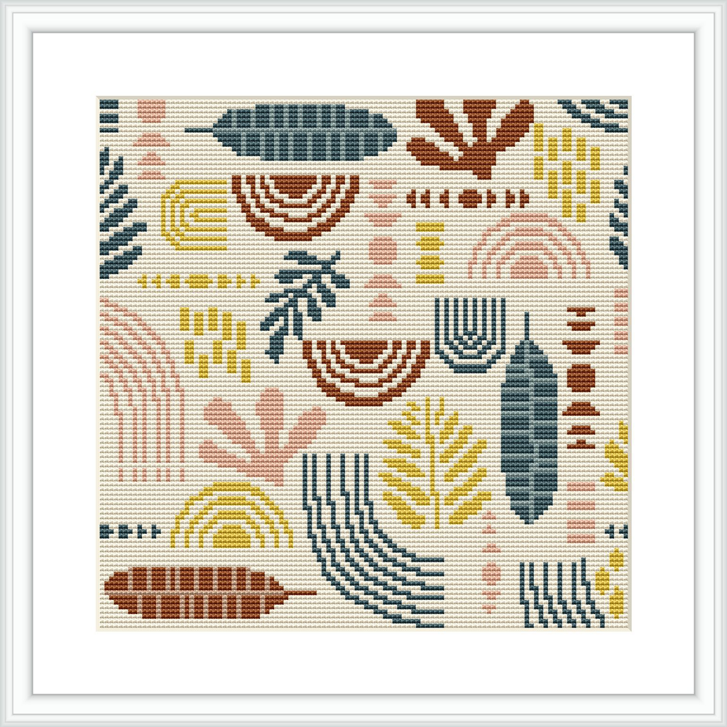 The image showcases a cross stitch pattern with a collection of stylized botanical elements such as leaves and feathers, arranged in a symmetrical layout. The design is framed and has a crisp, clean aesthetic, presenting a balance of shapes and colors.