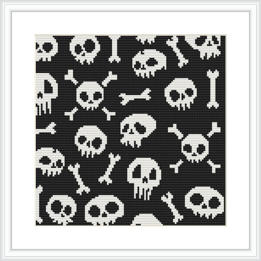 A framed cross stitch pattern depicting various skulls and bones in a monochromatic black-and-white color scheme against a dark background. The design is evenly spaced and features multiple repetitions of the skull and bones motif.