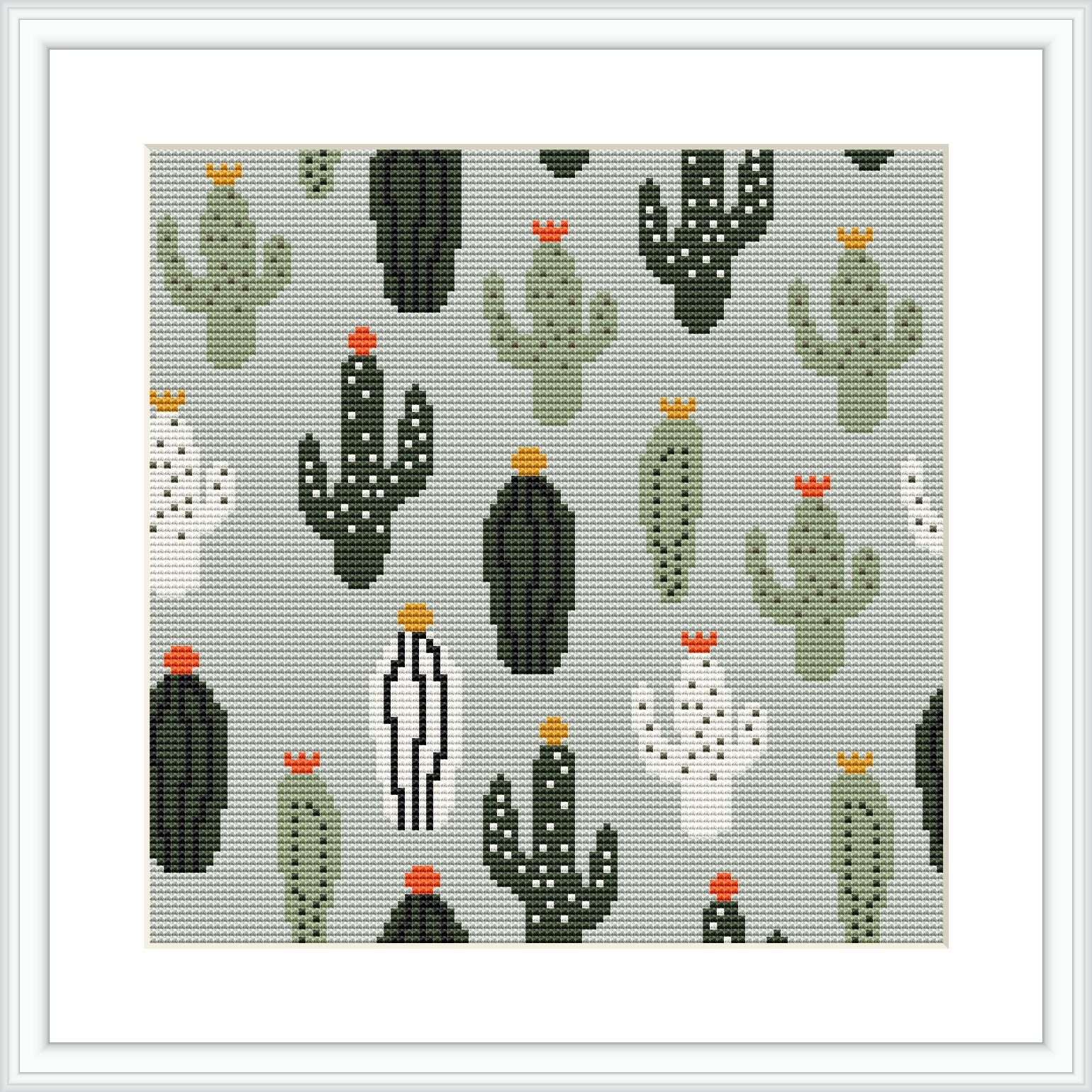 The image showcases a framed cross stitch pattern with multiple cacti varieties against a dotted gray background. Each cactus varies in shape and size, some with red or yellow flowers on top.