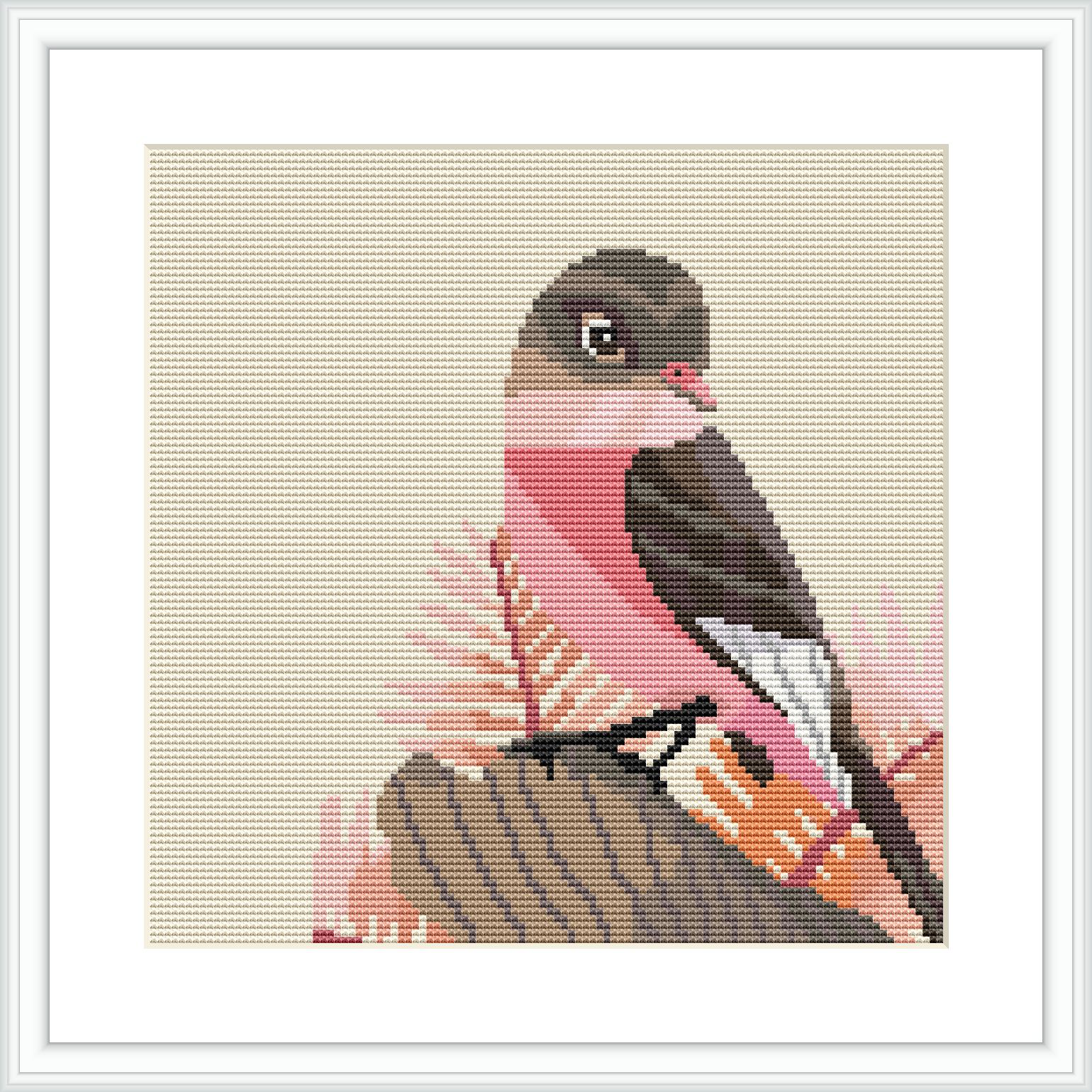 The image displays a cross stitch pattern of a gray bird with pink and brown accents, sitting on a perch against a cream background. The pattern is framed within a simulated white frame against a beige backdrop.