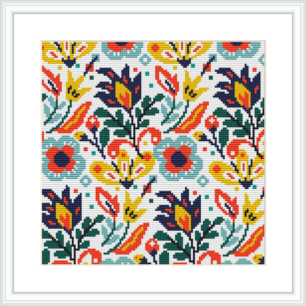 The image showcases a cross stitch pattern featuring a symmetrical arrangement of flowers and leaves in various colors. The pattern is displayed within a square frame and appears to be stitched on fabric.