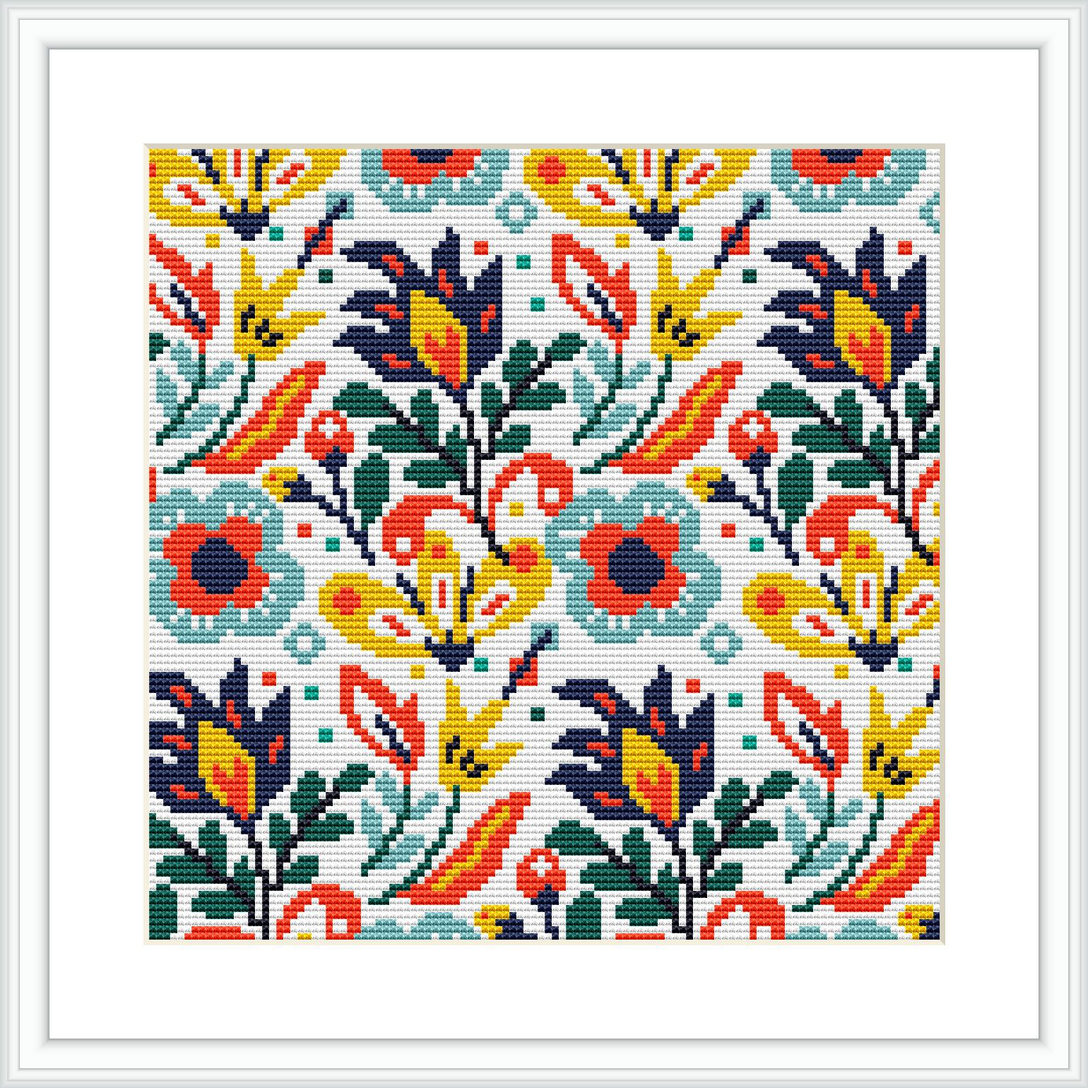 The image showcases a cross stitch pattern featuring a symmetrical arrangement of flowers and leaves in various colors. The pattern is displayed within a square frame and appears to be stitched on fabric.