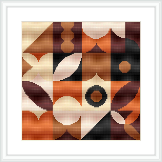 The image shows a framed cross stitch pattern featuring a geometric design with various abstract shapes and a dominance of brown tones. The design is depicted as fully stitched, displayed in a square frame, with a white border around the pattern.
