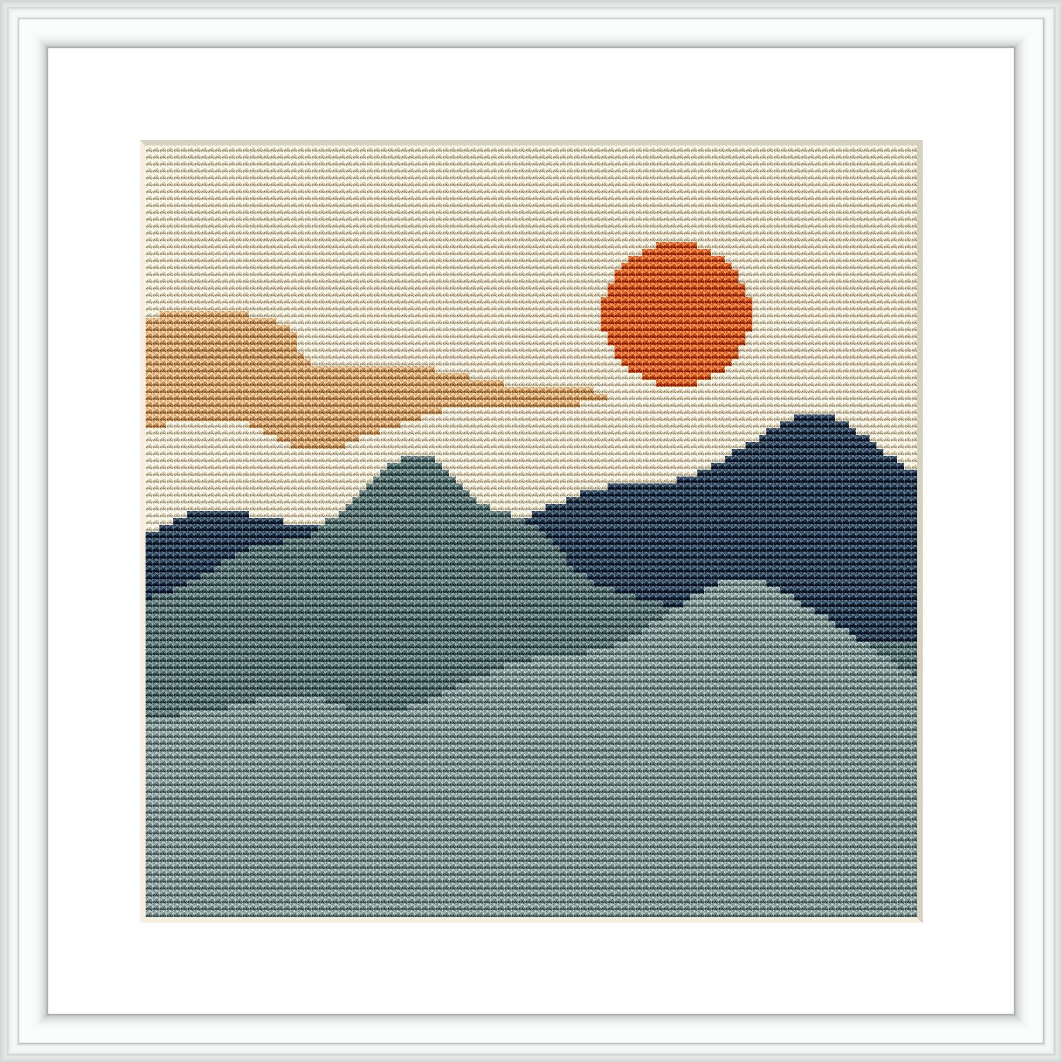 The image depicts a stylized cross stitch pattern of a landscape, showing a series of mountains in shades of green and blue, with a beige cloud streak and a round orange sun against a white background.