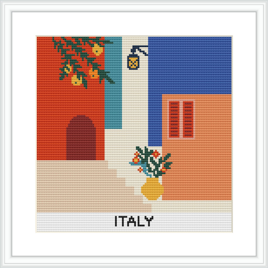 A cross stitch pattern depicting a quaint Italian street scene, featuring a red-orange building on the right, a blue building on the left with a green plant hanging, and a beige path in the center. The word 'ITALY' is stitched at the bottom, and a street lamp and a potted plant with blooming flowers are also visible.