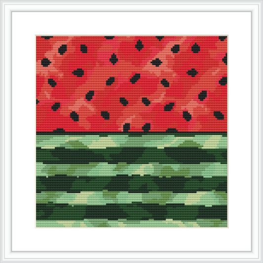 The image shows a cross stitch pattern of a watermelon. The upper section depicts the red flesh of the watermelon speckled with black seeds, transitioning into the watermelon rind which features varying shades of green beneath.