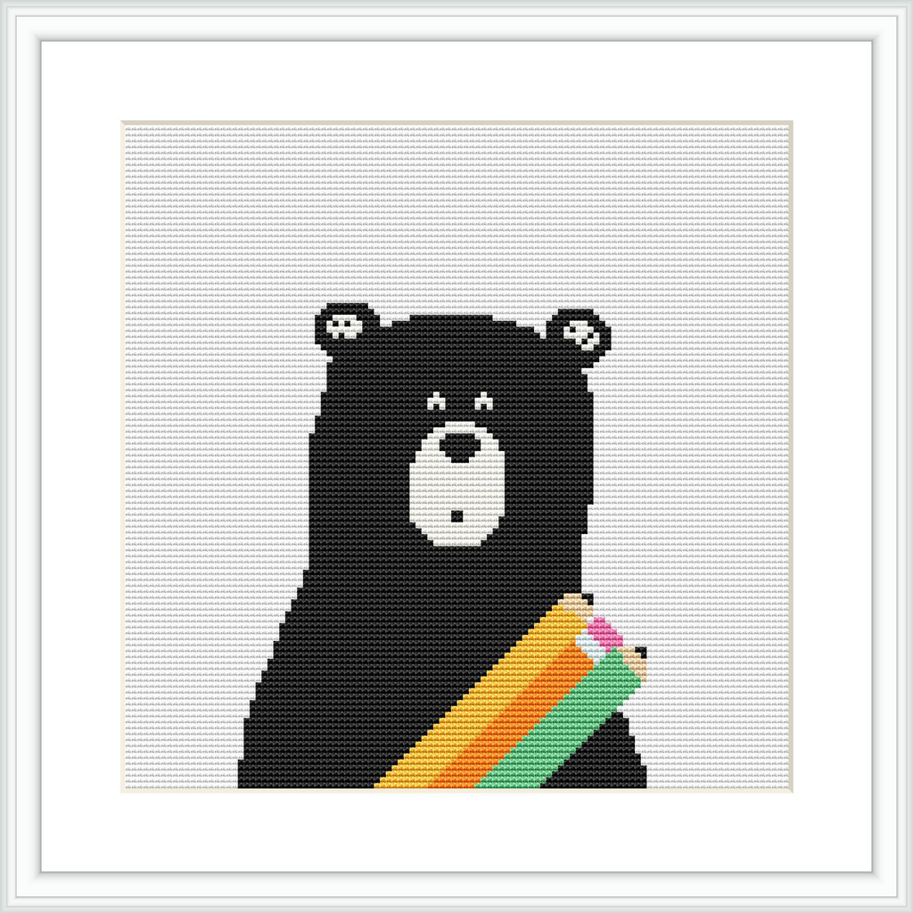 The image depicts a cross stitch pattern showcasing a black bear with a surprised expression. The bear has colorful stripes on its lower right, against a white background within a framed layout.