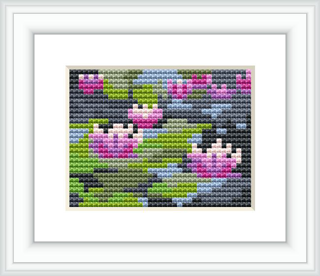 The image shows a framed cross stitch pattern that depicts an abstract interpretation of Claude Monet's Water Lilies. The pattern features stylized lily pads and flowers on a pond, with a color palette of pink, green, blue, and purple against a dark background.