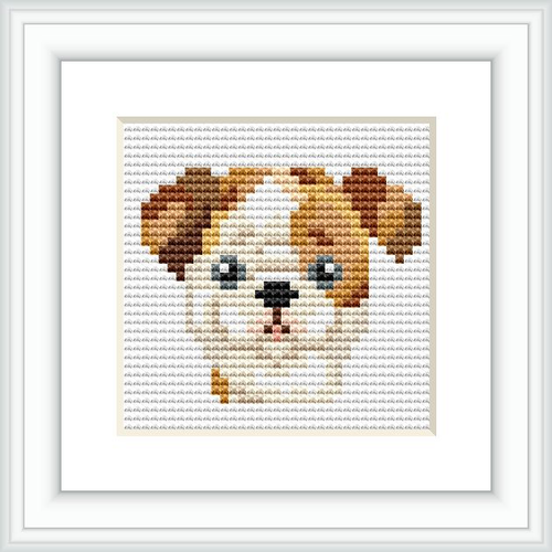 The image shows a framed square cross stitch pattern featuring a stylized representation of a brown and white bulldog's face with black detailing for the eyes, nose, and mouth. The pattern is complete and displayed against a white backdrop.