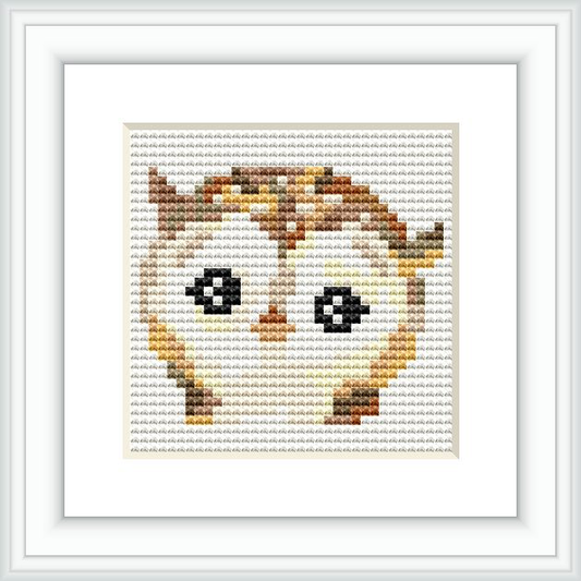 A framed cross stitch pattern depicting a stylized owl with large eyes, composed of stitches in a variety of earthy colors. The pattern is showcased within a simple square white frame against a white background.