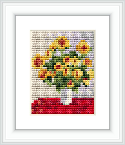 The image shows a framed cross stitch pattern with a design of a bouquet of sunflowers in a vase, presented in a grid-like composition with varied colors prominently displaying yellows and greens above a red base, resembling an Impressionist style of painting.