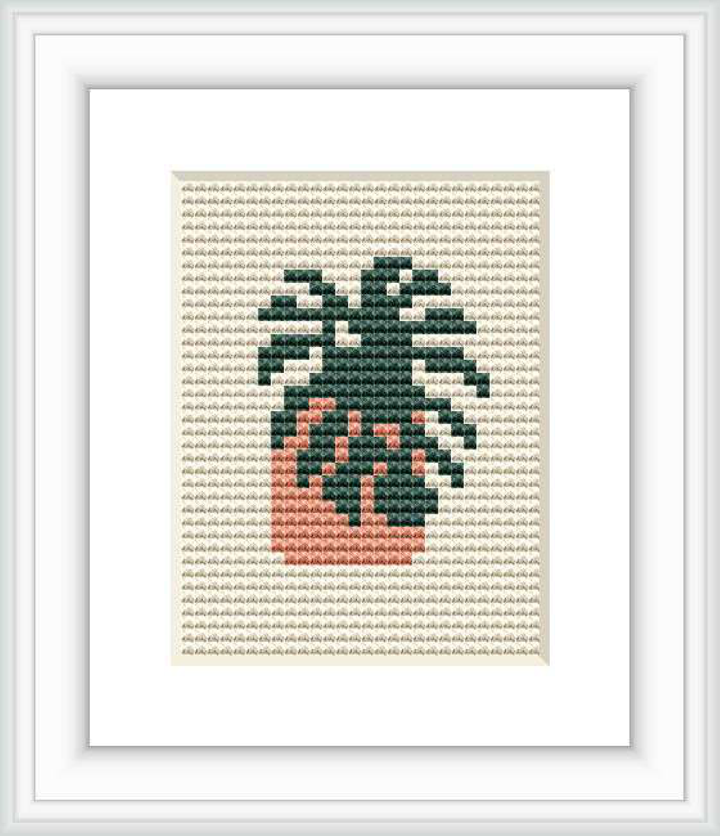 The image presents a framed cross stitch design depicting a mini monstera plant with green leaves and a peach-colored pot, stitched on a neutral taupe fabric background.