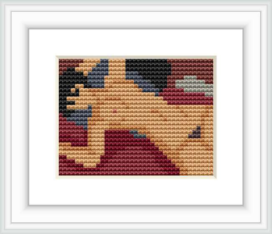 The image depicts a framed cross stitch pattern of a reclining figure influenced by Modigliani's 'Nu couché'. The pattern uses a variety of colored stitches to create an abstract representation of the figure.