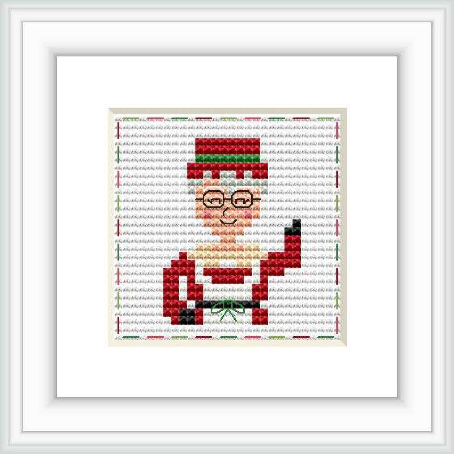 The image depicts a framed cross-stitch pattern of Mrs. Claus with glasses, wearing a red outfit with a green background on a wall.