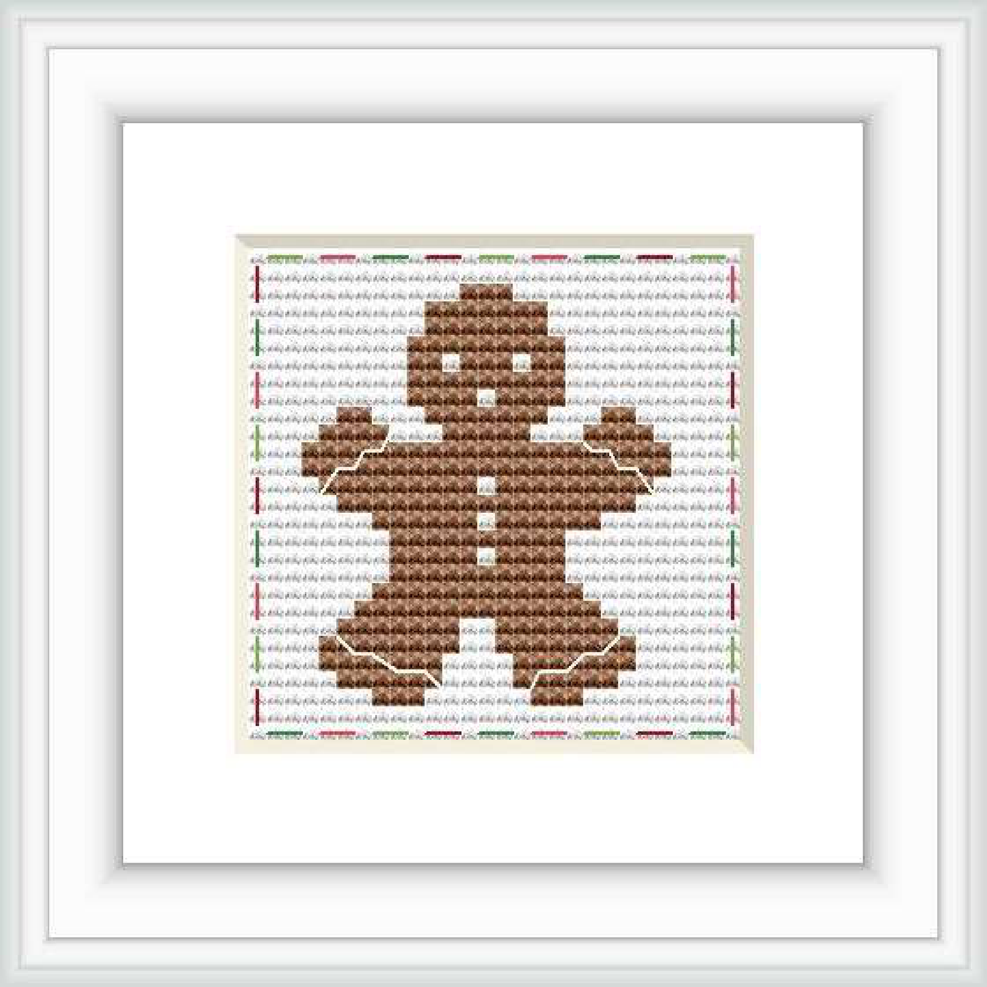 The image shows a completed cross stitch pattern of a gingerbread man centered on a white background, within a square frame. The pattern is detailed with colors mainly in shades of brown, with accent lines suggesting the gingerbread man's features and outlines.