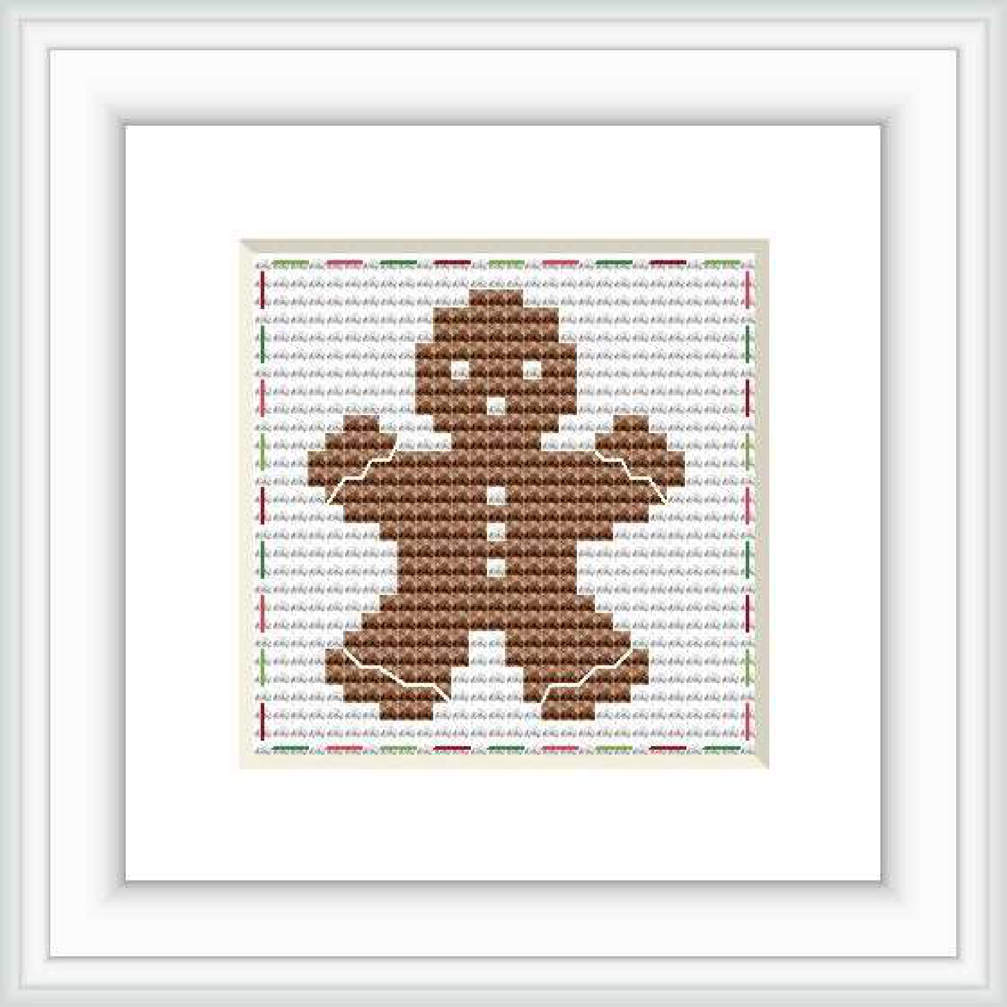 The image shows a completed cross stitch pattern of a gingerbread man centered on a white background, within a square frame. The pattern is detailed with colors mainly in shades of brown, with accent lines suggesting the gingerbread man's features and outlines.