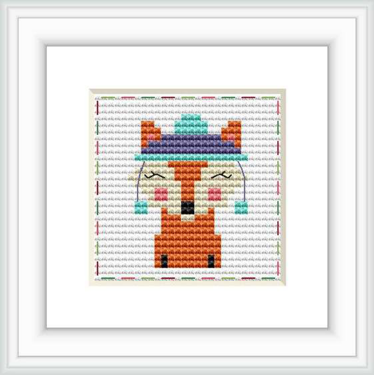 The image features a framed cross stitch pattern with a central depiction of a stylized fox set against a multicolored, stitch-textured background.