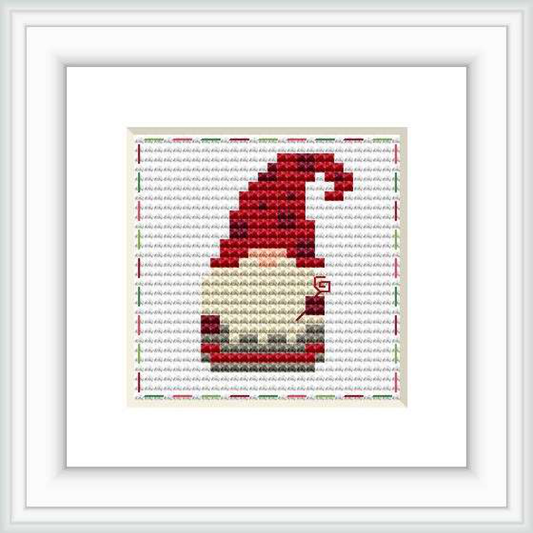 The image shows a cross stitch pattern of a gnome in profile, centered within a white background with a grey grid. The gnome is predominantly red with shades of grey, white, and beige, and a touch of green.