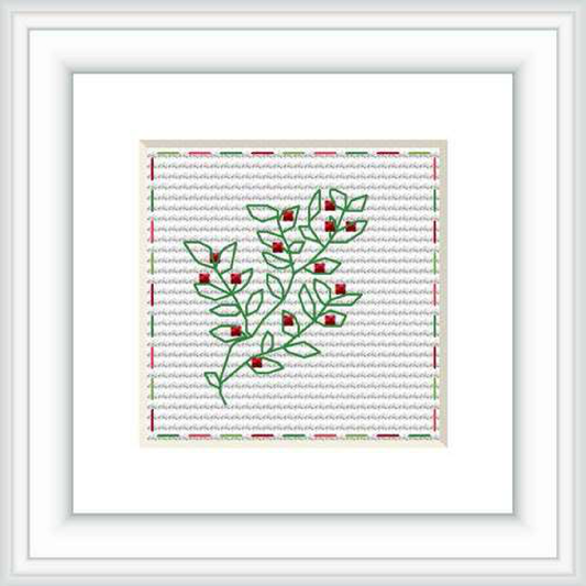 The image shows a framed cross stitch pattern of a simple green leafy branch with red accents on a structured gray background that is further bordered with a red line, all contained within a white mount and a light frame.