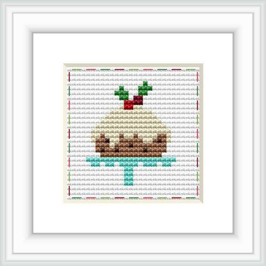 The cross stitch pattern features a stylized representation of a cake with multiple layers, decorated with green icing and topped with a red design. It's framed within a simple rectangular border.