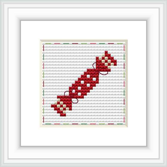 The image showcases a cross stitch pattern of a nutcracker depicted in a pixel art style. The pattern is centered on a square grid, against a white background with grey horizontal lines and a burgundy border.