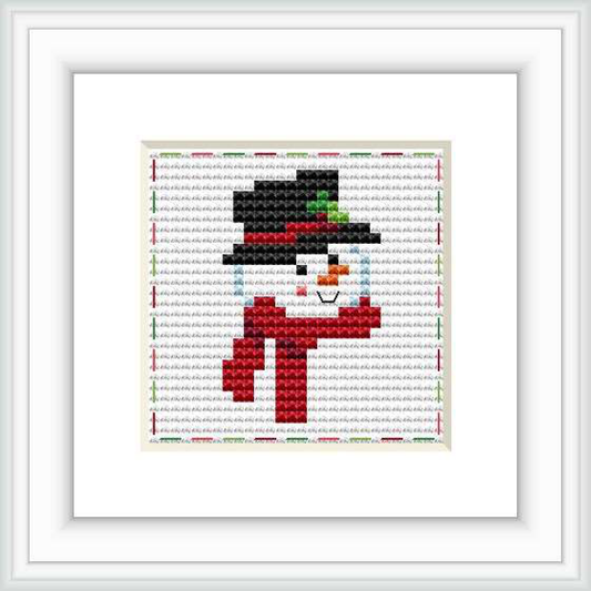 The image displays a framed cross stitch pattern featuring a stylized snowman wearing a top hat and scarf, centered on a stitch grid background.