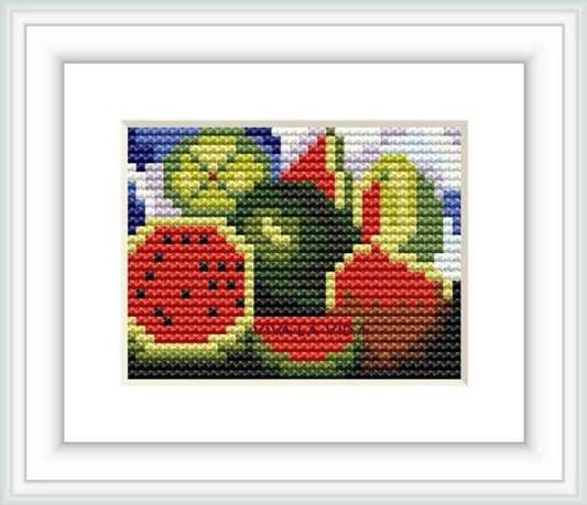 The image shows a framed cross stitch pattern featuring abstracted shapes and colors that resemble the style of Frida Kahlo's art.