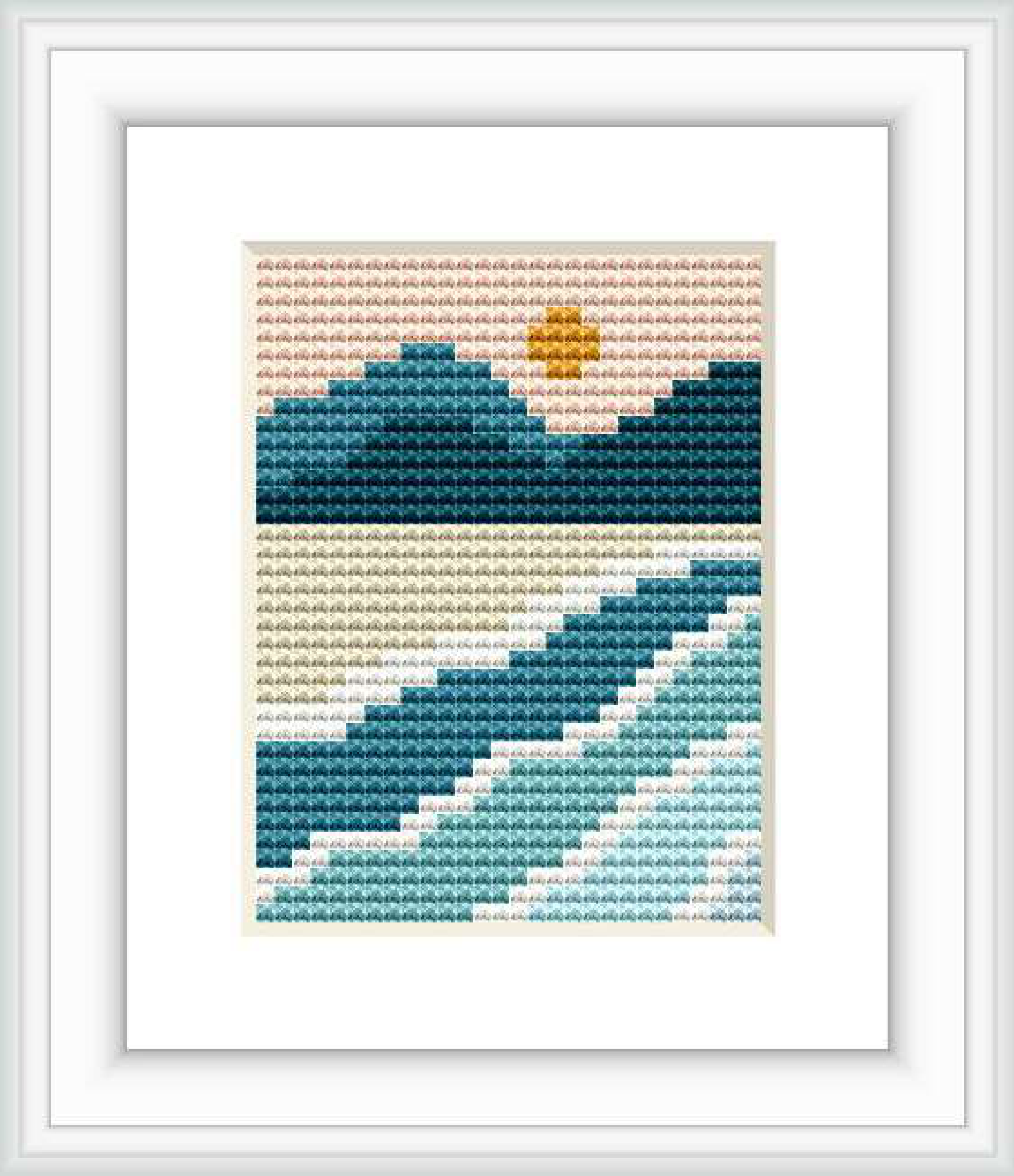 The image features a framed cross stitch pattern that depicts a stylized mountain landscape. There are three layers of mountains with varying shades of blue and green, a beige sky with a small yellow sun, and a patterned border that frames the picturesque scene.