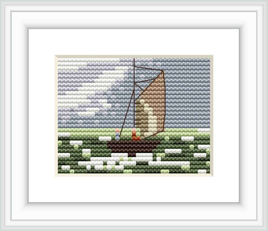 The image depicts a small cross stitch pattern featuring a sailboat on water with waves, likely inspired by a Claude Monet painting. It is framed and the background has various shades of blue and green, resembling the ocean.