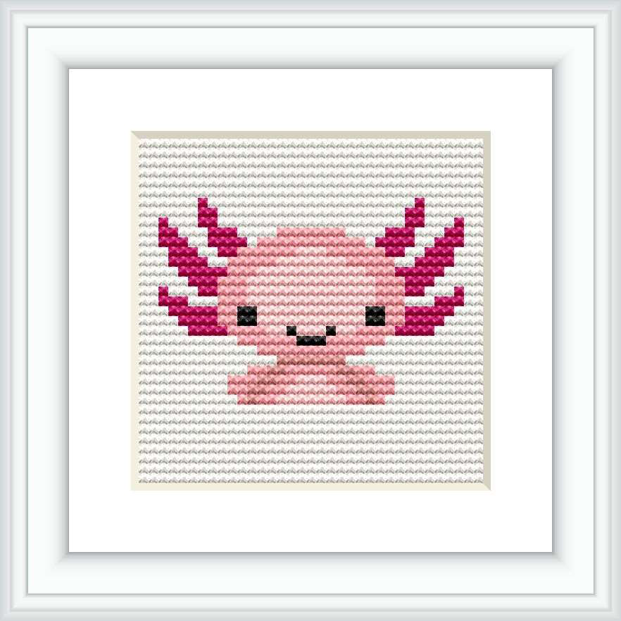 The image displays a square cross stitch pattern featuring a stylized axolotl in a simplistic, cartoonish form. The pattern is predominantly pink with accents in magenta, white, and black, framed within a classic frame, against a white background.