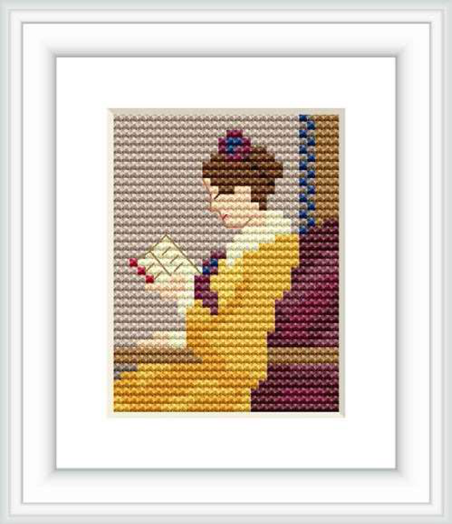 The image shows a cross stitch pattern of a young girl in a yellow dress reading a letter. She is sitting beside a blue-striped element, possibly a wall or curtain, with a maroon backdrop behind her. A light beige field surrounds the central figure.