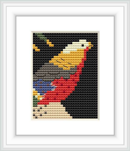 The cross stitch pattern depicts a stylized bird in profile with its beak pointing upwards. It appears amidst dark background with elements of blossoms and leaves. The pattern is framed and presented on a plain background.