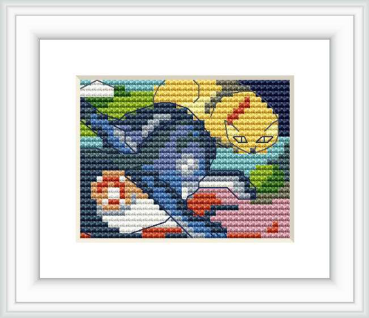 A framed cross stitch pattern depicting two stylized cats, one blue and one yellow against a colorful background, encased within a white border and frame.
